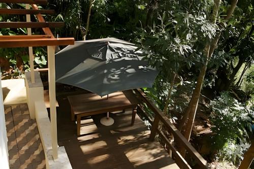 an umbrella sitting on top of a bench at Natureza e Sossego em BH in Macacos