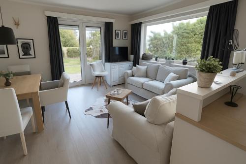 a living room with white furniture and a dining room at Willkommen in Ihrem sonnigen Gartenapartment in Kitzbühel