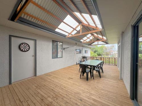 a dining room with a table and chairs on a deck at Esperance Bay Retreat in Esperance