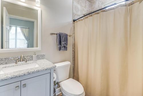 a bathroom with a toilet and a sink and a mirror at Poolside Paradise Condo in Long Beach