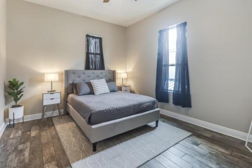 a bedroom with a bed and two windows at Poolside Paradise Condo in Long Beach