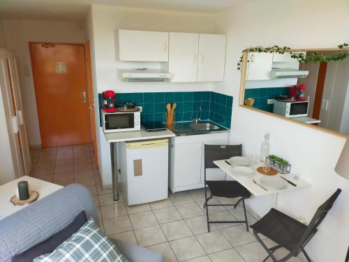 une petite cuisine avec un canapé et une table dans l'établissement Studio climatisé Avenue 83 à 10mn de Hyères et de Toulon, à La Valette-du-Var