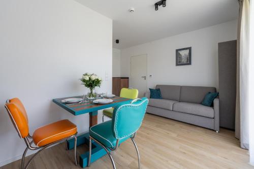 a living room with a table and chairs and a couch at Apartamenty Dolina Jawornika in Wisła