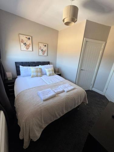 a bedroom with a bed with two towels on it at 3 bedroom Falkirk flat in Falkirk