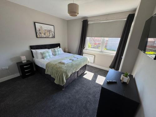 a bedroom with a large bed and a window at 3 bedroom Falkirk flat in Falkirk