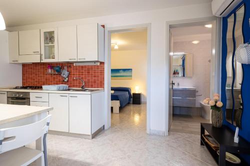 a kitchen and living room with white cabinets at red home relax vista mare in Capilungo