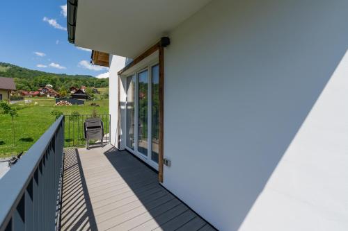 a balcony with a door and a chair on it at Apartamenty Dolina Jawornika in Wisła