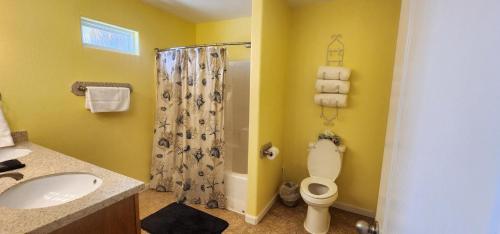 Un baño con inodoro, ducha y lavabo. en Tipsy Turtle - relax, unwind, you're on turtle time, en Port Aransas
