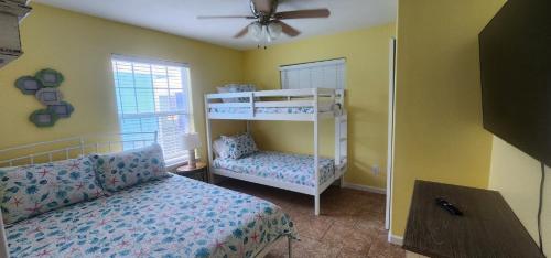 un dormitorio con una cama y una litera en Tipsy Turtle - relax, unwind, you're on turtle time, en Port Aransas
