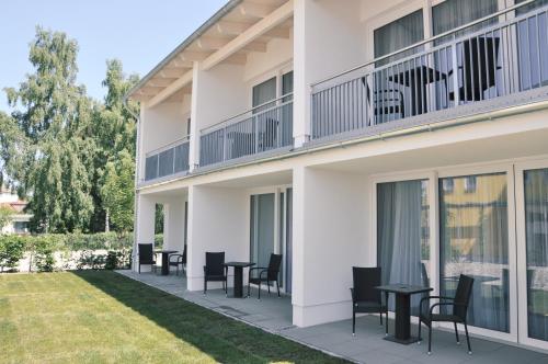 a balcony of a building with chairs and tables at SEETELHOTEL Nautic Usedom Hotel & Spa das Hotel für Wellness & Genuss auf Usedom in Ostseebad Koserow