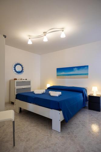 a bedroom with a blue bed in a white room at red home relax vista mare in Capilungo