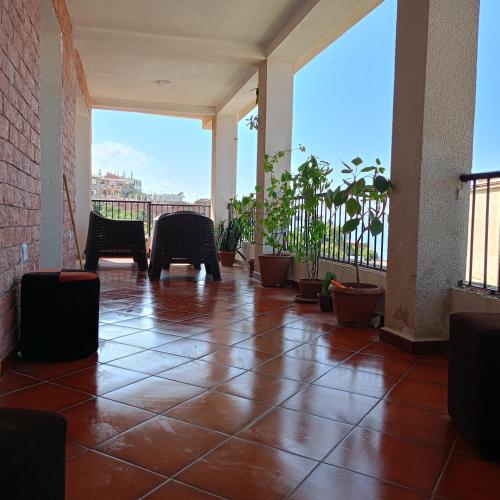 a patio with tables and chairs on a balcony at Gîte de vacances Béjaïa in Bejaïa