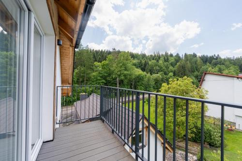 a balcony with a view of the woods at Apartamenty Dolina Jawornika in Wisła