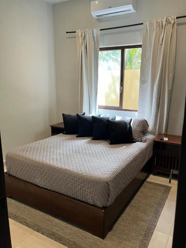 a bedroom with a large bed with a window at Casa Xunan - Beautiful 1 Bedroom Apartment with pool in Mahahual