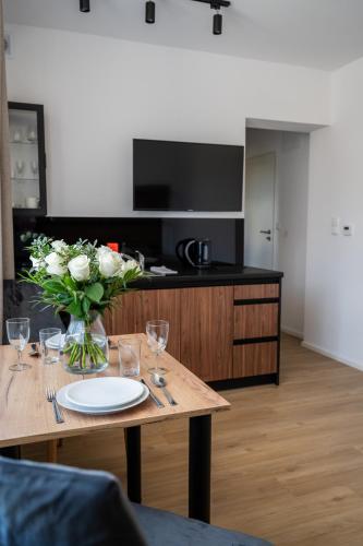 a kitchen with a table with a vase of flowers at Apartamenty Dolina Jawornika in Wisła