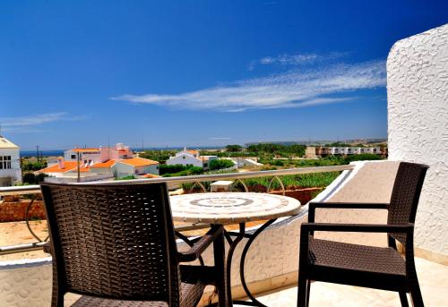 a patio with two chairs and a table on a balcony at Tonel Apartamentos Turisticos in Sagres
