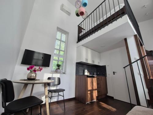 a living room with a table and a staircase at Inga Vacation House in Druskininkai