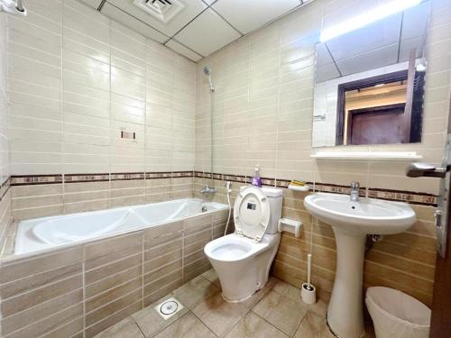 a bathroom with a tub and a toilet and a sink at Simple Stay Partition Room In Barsha heights Tecom in Dubai