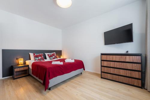 a bedroom with a bed and a flat screen tv at Apartamenty Dolina Jawornika in Wisła
