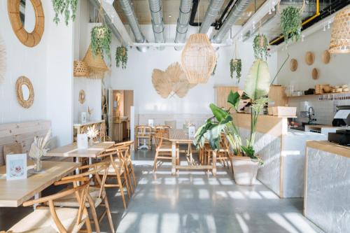 a restaurant with wooden tables and chairs and plants at Sweet Coffee Stay in Hasselt