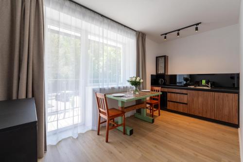 a living room with a table and a kitchen with a window at Apartamenty Dolina Jawornika in Wisła