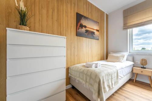 a bedroom with white dressers and a bed at Osada Kalwa in Tylkowo