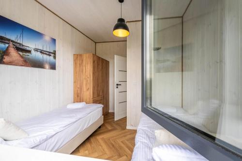 a bedroom with two beds and a glass shower at Osada Kalwa in Tylkowo