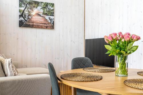 a dining room with a table with flowers in a vase at Osada Kalwa in Tylkowo