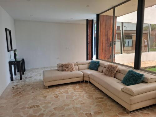 a living room with a couch and large windows at Finca Villa Gabriela 