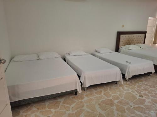 a group of three beds in a room at Finca Villa Gabriela 
