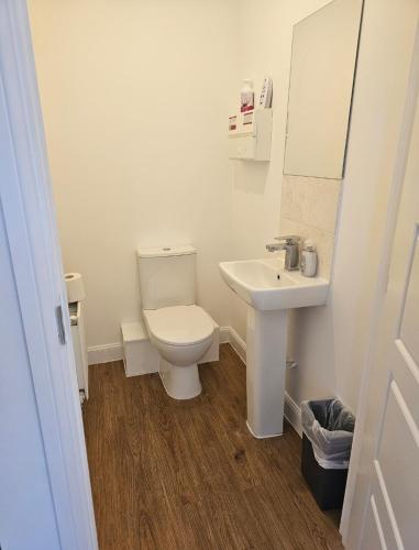 a white bathroom with a toilet and a sink at Luxury Kingsize Bedroom with Dedicated Toilet- Central Dartford in Dartford