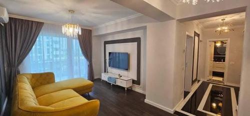 un soggiorno con un divano e una televisione di Exquisite Prima a Oradea