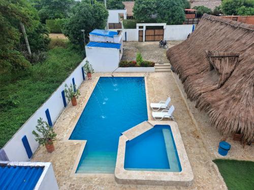 an overhead view of a swimming pool with a thatch roof at Finca Villa Gabriela 