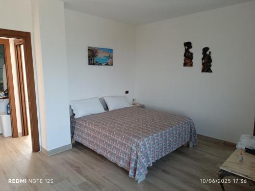 a bedroom with a bed in a white room at La Dimora di Nonna Anna in Casal Velino
