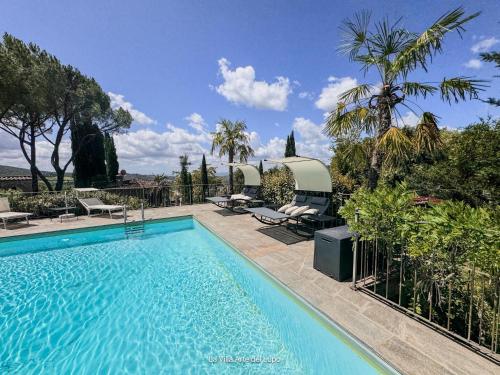 a swimming pool with two chaise lounges next to a fence at Ferienwohnung Fortuna del Lupo mit Pool und Aussicht in Subbiano