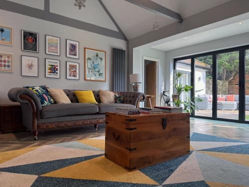 a living room with a couch and a coffee table at Historic Hampshire Cottage with Private Putting Green in Eversley
