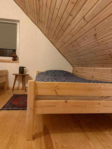 a bed in a room with a wooden ceiling at Agroturystyka u Smerfa in Ugoszcz