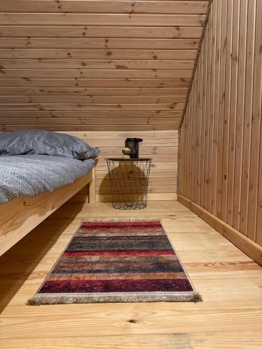 a bedroom with a bed and a rug on a wooden floor at Agroturystyka u Smerfa in Ugoszcz