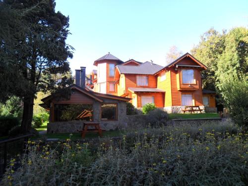 a large house with a gazebo in front of it at Apart Hotel del Pellin in San Martín de los Andes