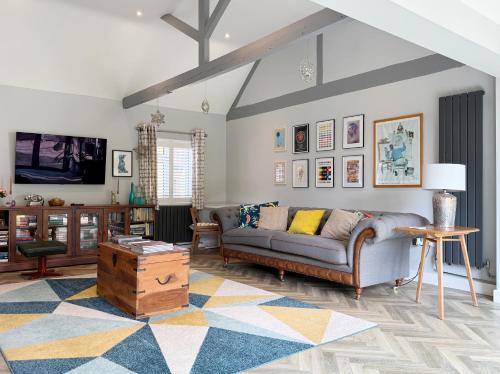 a living room with a couch and a table at Historic Hampshire Cottage with Private Putting Green in Eversley