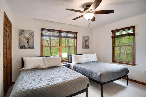 a bedroom with two beds and a ceiling fan at Elk Ridge Retreat -Hot Tub- Firepit-Fireplace in Maggie Valley