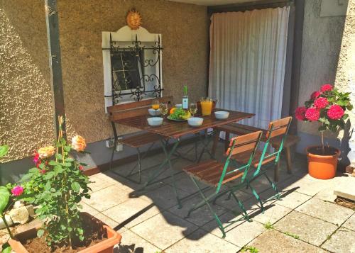 a table and chairs in a patio with flowers at Book-A-Room Salzburg Apartment 5-6-7-8 in Salzburg