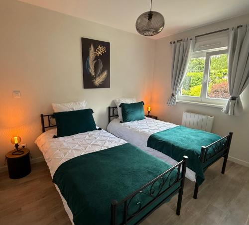 two twin beds in a room with a window at Au Jardin Secret in Rimsdorf