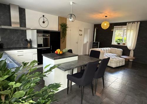 a kitchen and living room with a table and chairs at Au Jardin Secret in Rimsdorf
