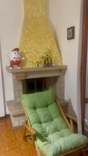 a room with a fireplace with a green couch at Appartamento Giacomo Leopardi in Piobbico