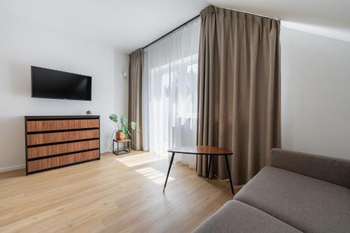 a living room with a couch and a tv at Apartamenty Dolina Jawornika in Wisła