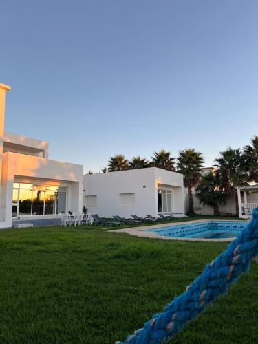a house with a swimming pool in front of it at Villa Belle Rive Estate in Oulad Akkou