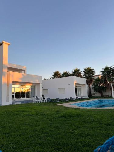 a villa with a swimming pool and a house at Villa Belle Rive Estate in Oulad Akkou