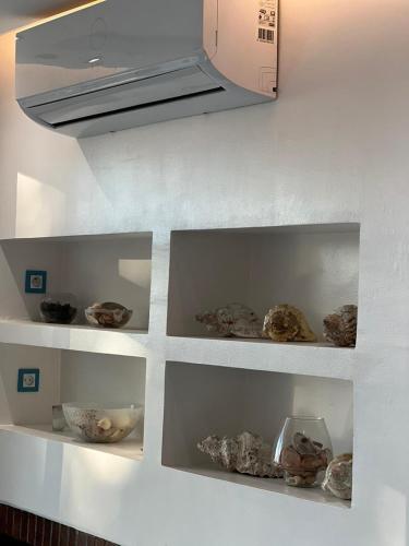 a kitchen with shelves filled with rocks and a microwave at Villa Belle Rive Estate in Oulad Akkou