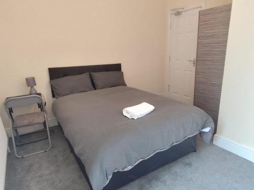 a bedroom with a bed with a white towel on it at En-Suite Double-Bedroom in the Heart of Salford Manchester CR4 Perfect for Short Stays in Manchester